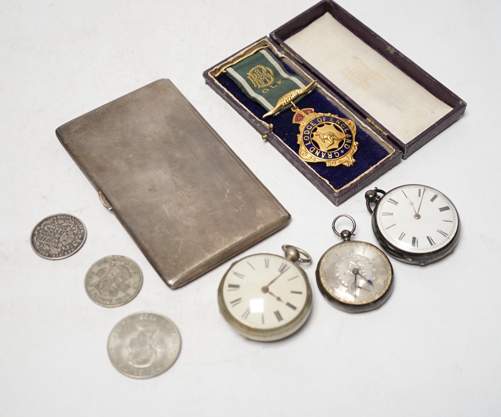 A George V engine turned silver cigarette case, 14.2cm, three pocket watches including two silver and a small group of coins and medals. Condition - poor to fair